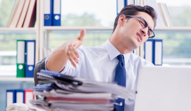 male working in a cluttered office